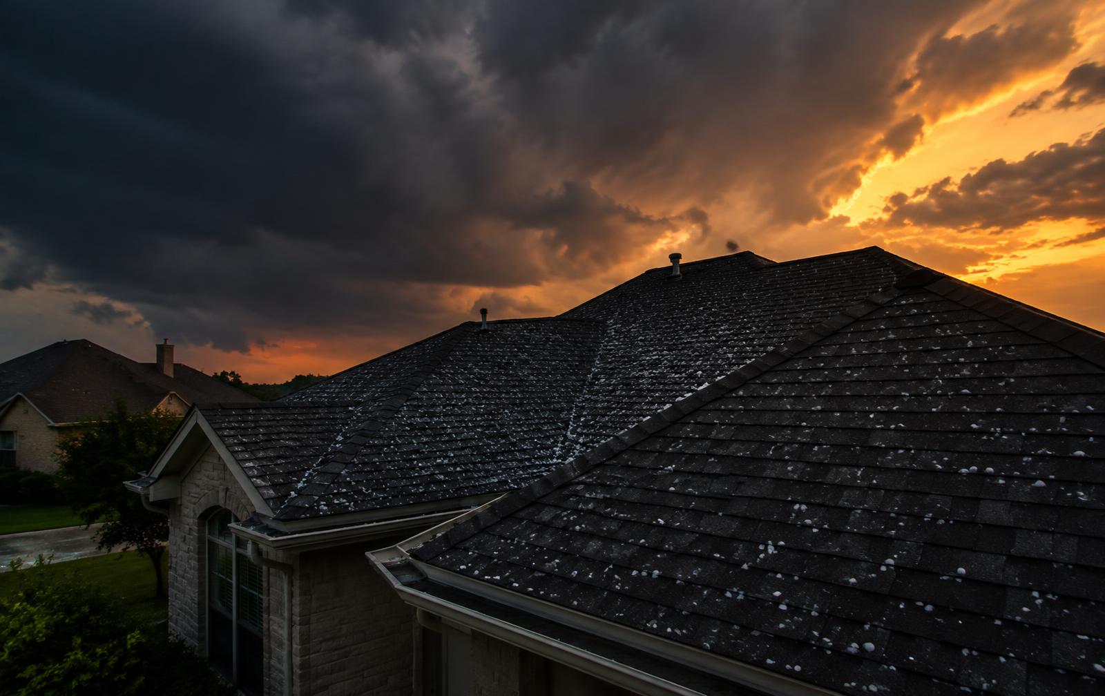 Hail on a Texas roof under storm clouds